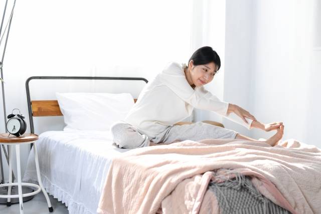 ベットの上でストレッチをするイメージ画像