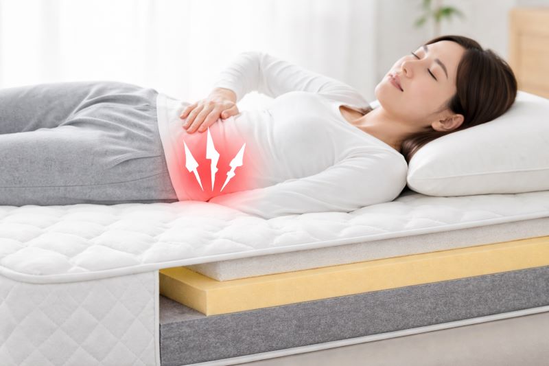 マットレスが硬すぎて腰に負担がかかるイメージ｜寝ているときの腰痛の原因